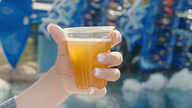person holding a beer at seaworld promoting free beers for every visitor this summer