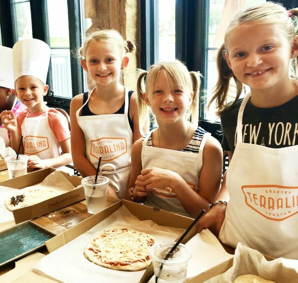 Smiling children making pizza at Terralina Crafted Italian Kitchen