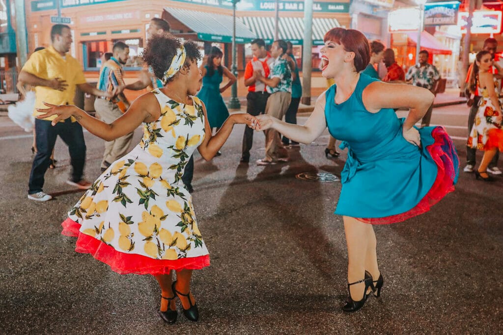 Dancers in the street smiling enjoying the atmosphere of  ¡Vamos Báilalo!