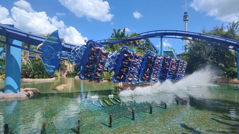 Riders smiling as they swoop face first over water on Manta at Seaworld