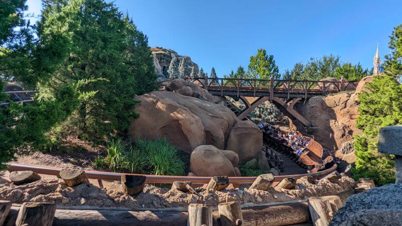Riders enjoying one of the drop turns in the tightly packed layout of Seven Dwarfs Mine Train Ride