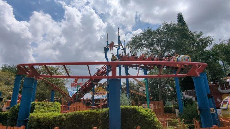 Riders cresting the lift hill of Woody Woodpecker's Nuthouse Coaster