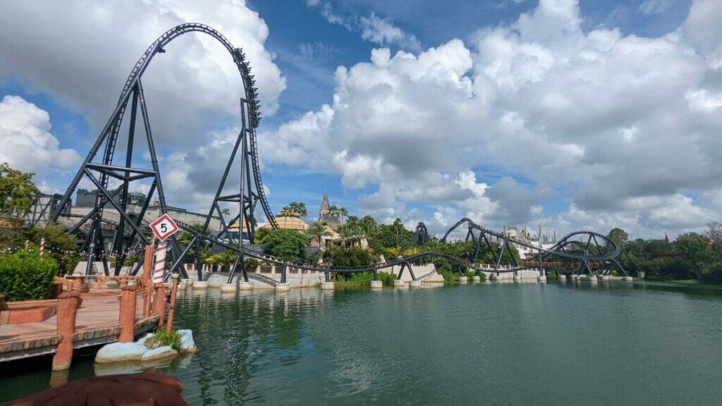 A Velocicoaster train diving down the 155 foot top hat element on a sunny afternoon in Islands Of Adventure