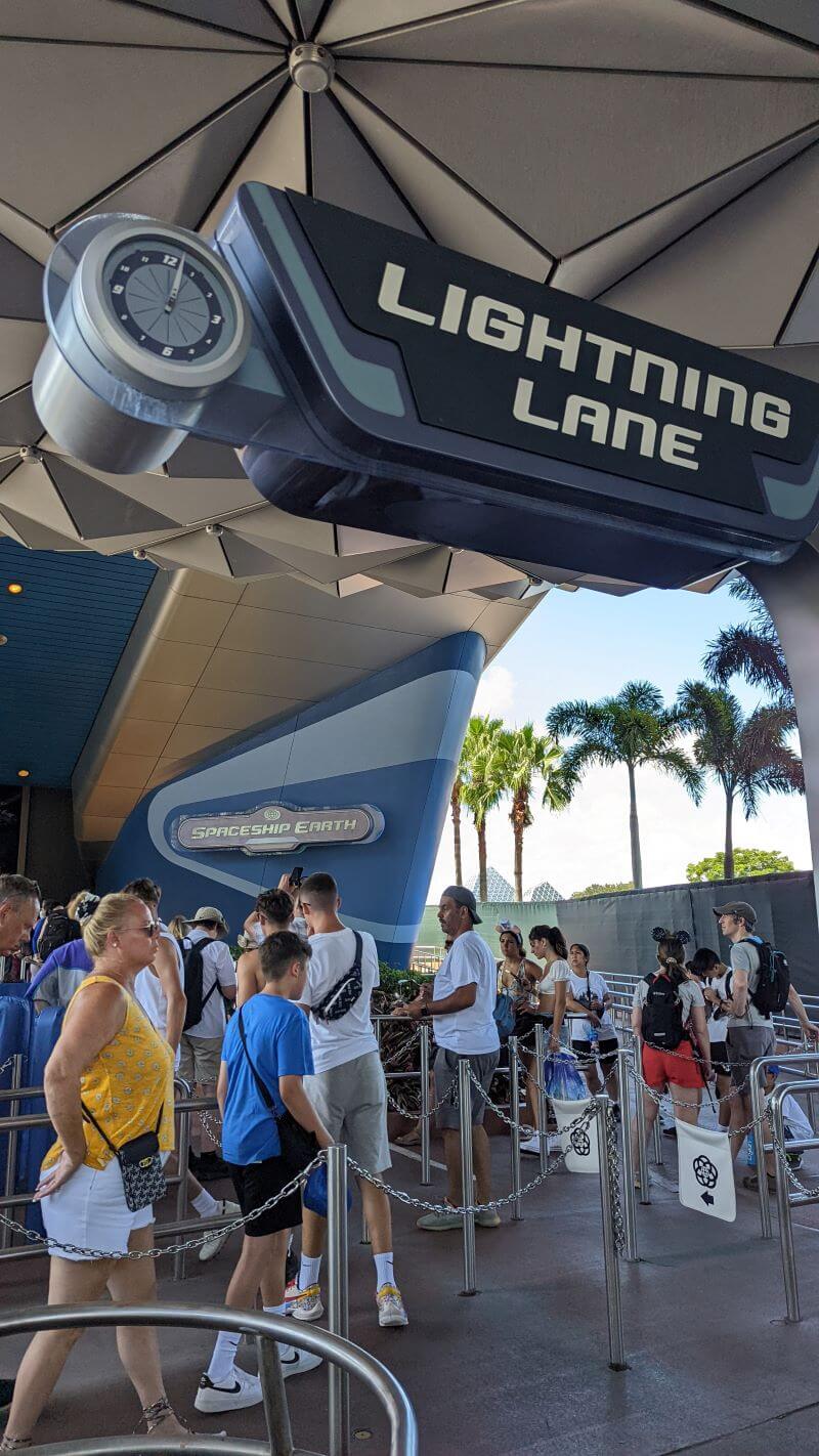 Guests queuing for Spaceship Earth under the Lightning Lane sign