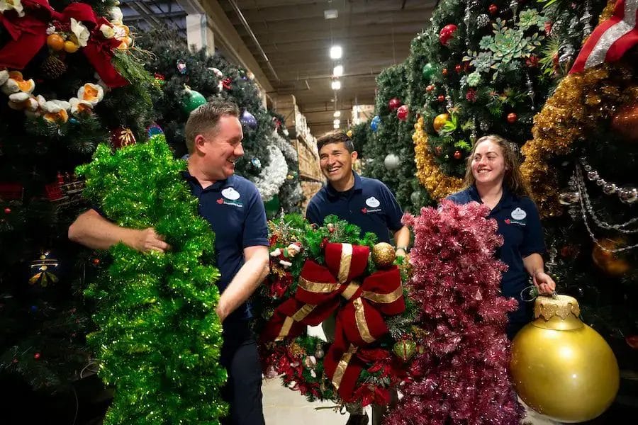 Disney World's Holiday Services team in a warehouse full of Christmas decorations ready for the parks 