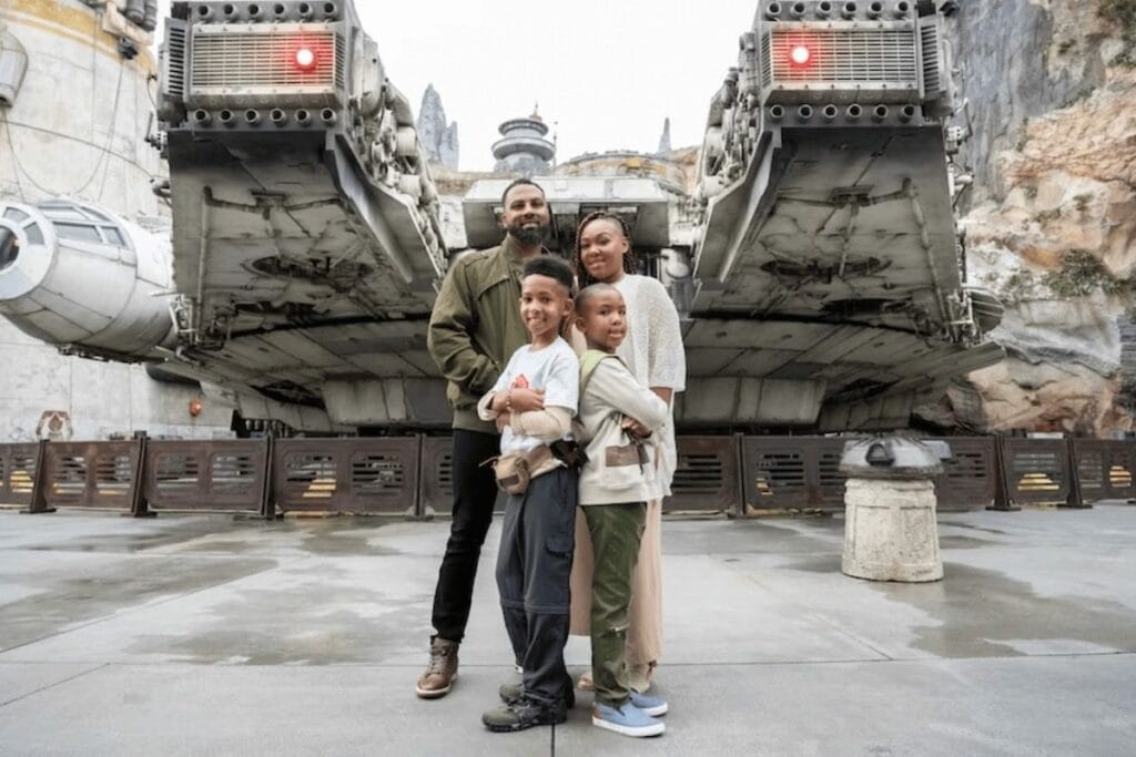 Family capturing a moment standing in fron of the Millenium Falcon in Star Wars Galaxy's Edge