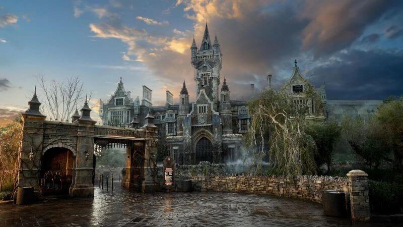 Official Epic Universe Dark Universe photo showing Frankensteins Manor over a body of water at sunrise