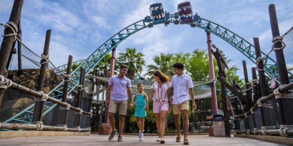 A family enjoying the park in front of Cobra's Curse. 